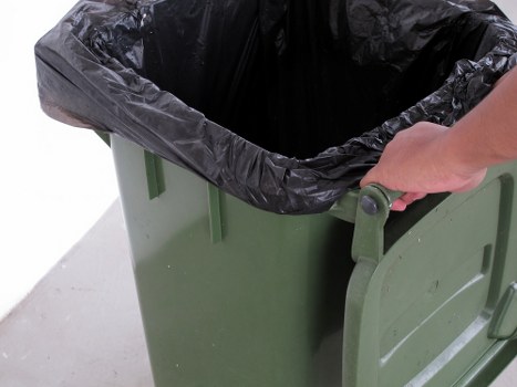 Technician using a tablet to schedule a commercial waste pickup in Enfield